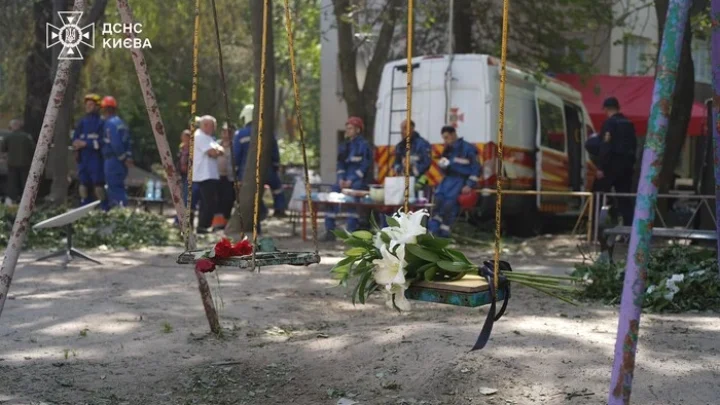 Кияни несуть квіти до знищеного росіянами будинку, де тривають пошукові роботи (фото)